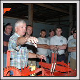 LINCOLN COUNTY Farm Bureau President Jerry Wyant, front, talks to a group of firefighters who attended a farm safety program at his farm about the potential for danger when using the knotter on a hay baler.