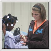 Students lined up as Milo Lewis, right, chair of the Young Farmers & Ranchers Committee at North Carolina State University, showed them how to hold a baby chick. 
