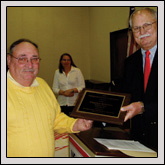 Robeson County Farm Bureau Vice President Charles Roberts, left, receives the Robeson County Crop Promotion Association's Distinguished Service to Agriculture Award from Robeson Regional Agricultural Fair President Coble Wilson.