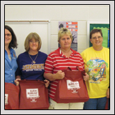 Macon County Farm Bureau’s Women’s Committee member Devon Deal, left, presents goodie bags to Macon County Schools bus drivers and Schools Superintendent Dan Brigman.